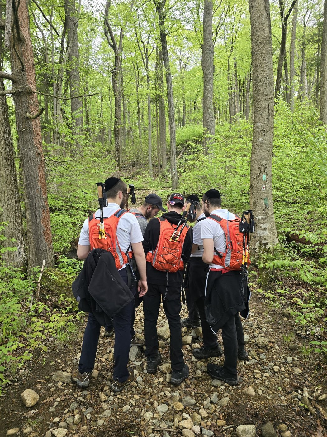 Chavivim SAR members hiking through wooded trail with rescue packs