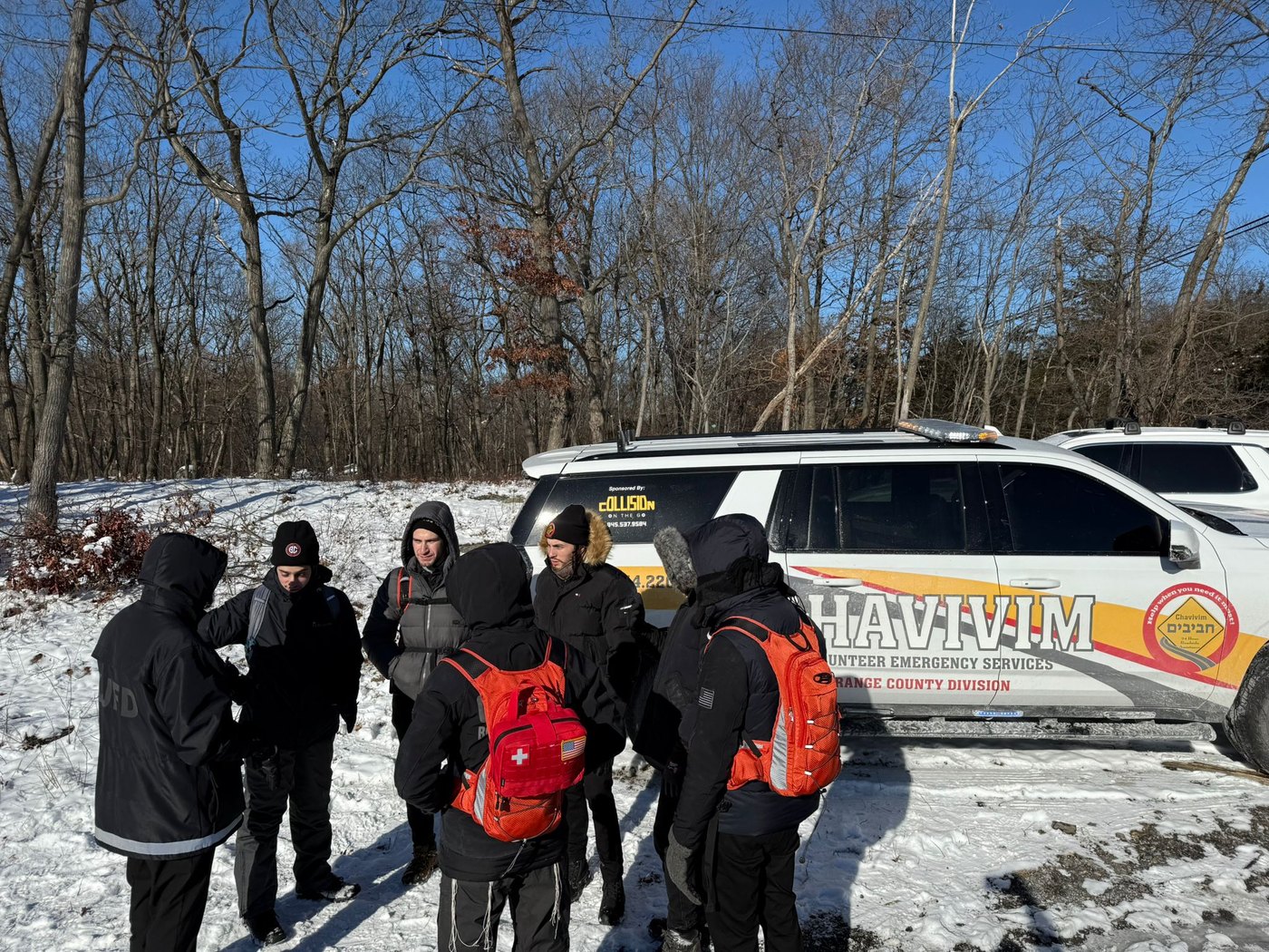 Chavivim SAR team in winter conditions next to a branded response vehicle